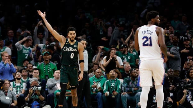 Boston Celtics forward Jayson Tatum (0) acknowledges the crowd as Philadelphia 76ers center Joel Embiid (21) looks away during the fourth quarter at TD Garden.